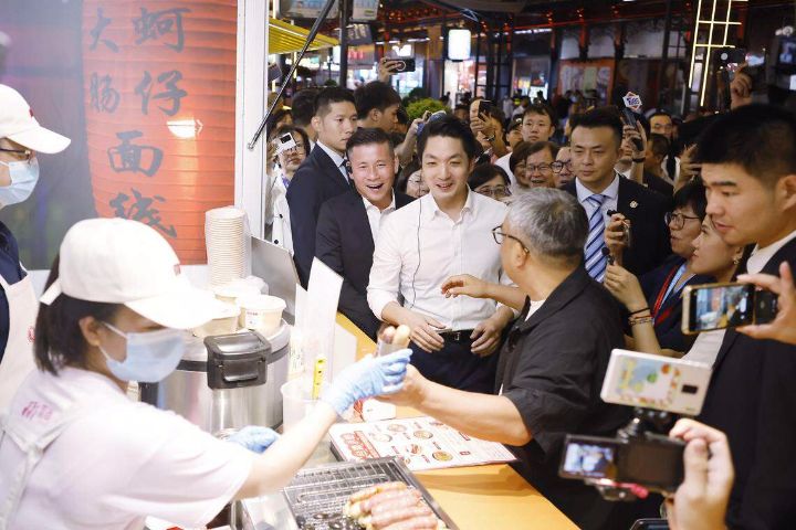 台北市长蒋万安逛上海夜市品尝美食与民众互动，推销台北欢迎大家到台北玩